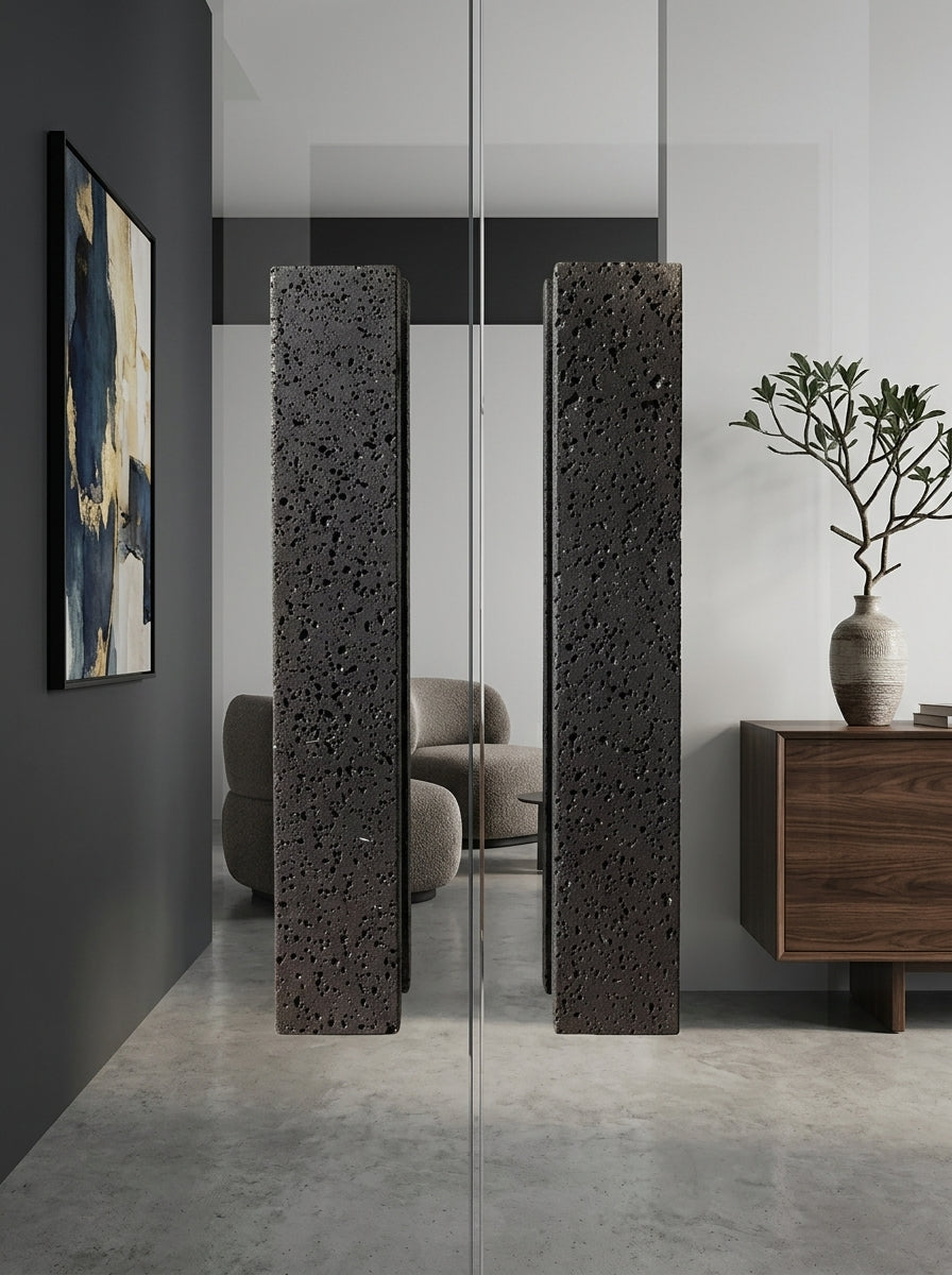 Black basalt bar stone door pull pair on a frameless glass door in a modern minimalist living room