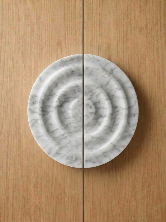 Yukixstone Bianco Carrara natural stone disc pull pair - hand-carved round marble door pull with concentric ripple carving, split across a pair of doors