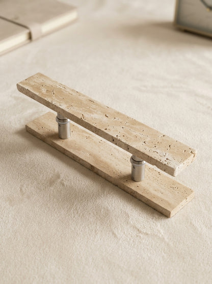 Construction detail of the travertine bar door pull showing the stone bar, brushed stainless steel posts and backplate