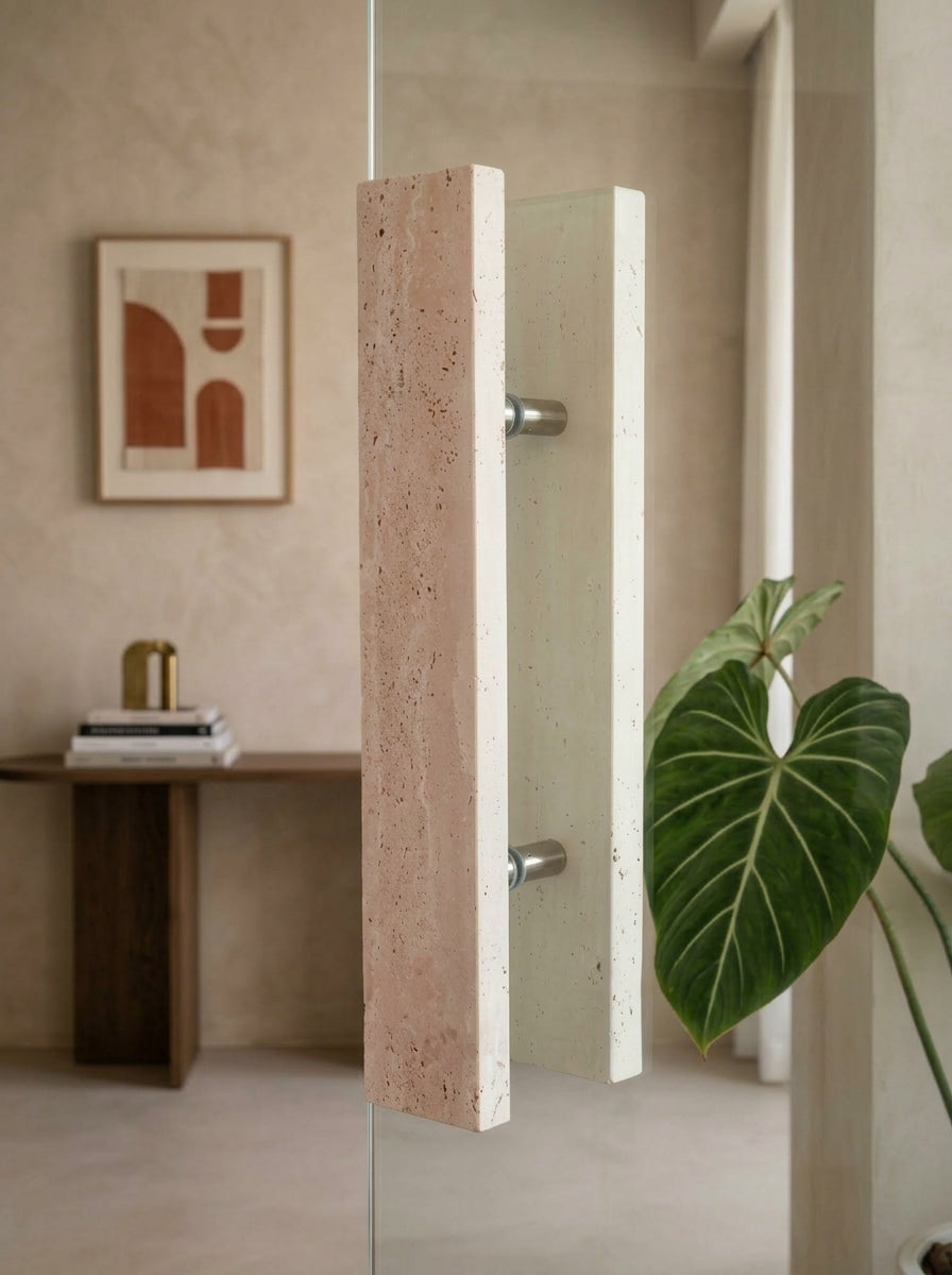Beige travertine bar stone door pull mounted back-to-back on a frameless glass door with stainless steel standoffs