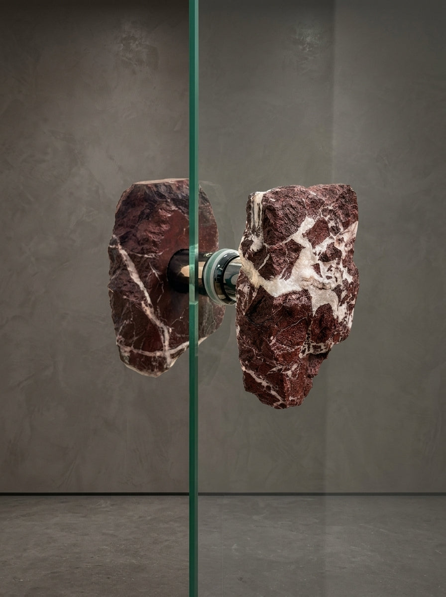 Close-up of brecciated jasper glass door pull showing white quartz veining and stainless steel standoff