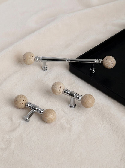 Short and long travertine ball chrome pulls side by side on fabric