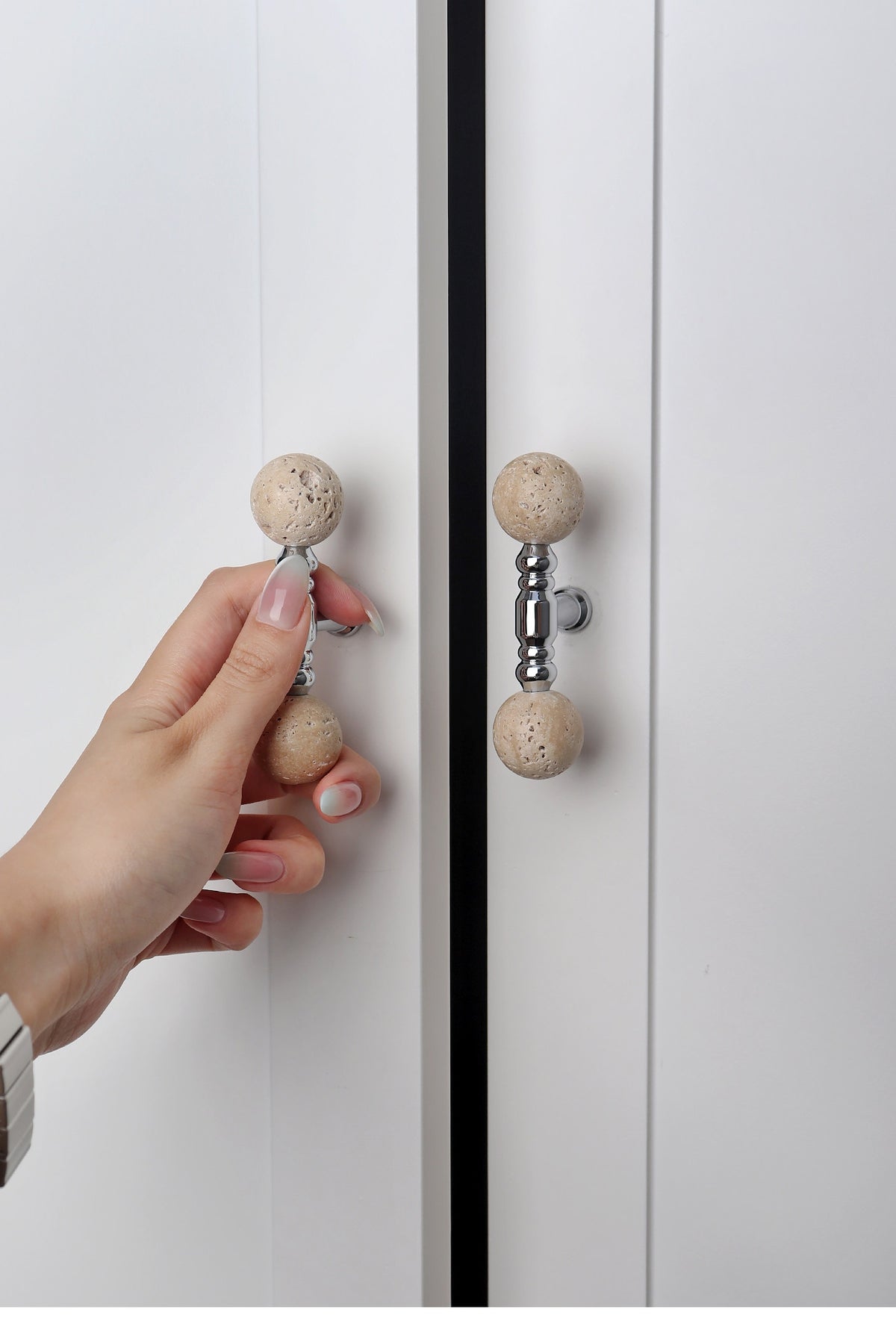 Hand opening a cabinet with a short travertine ball T-bar pull