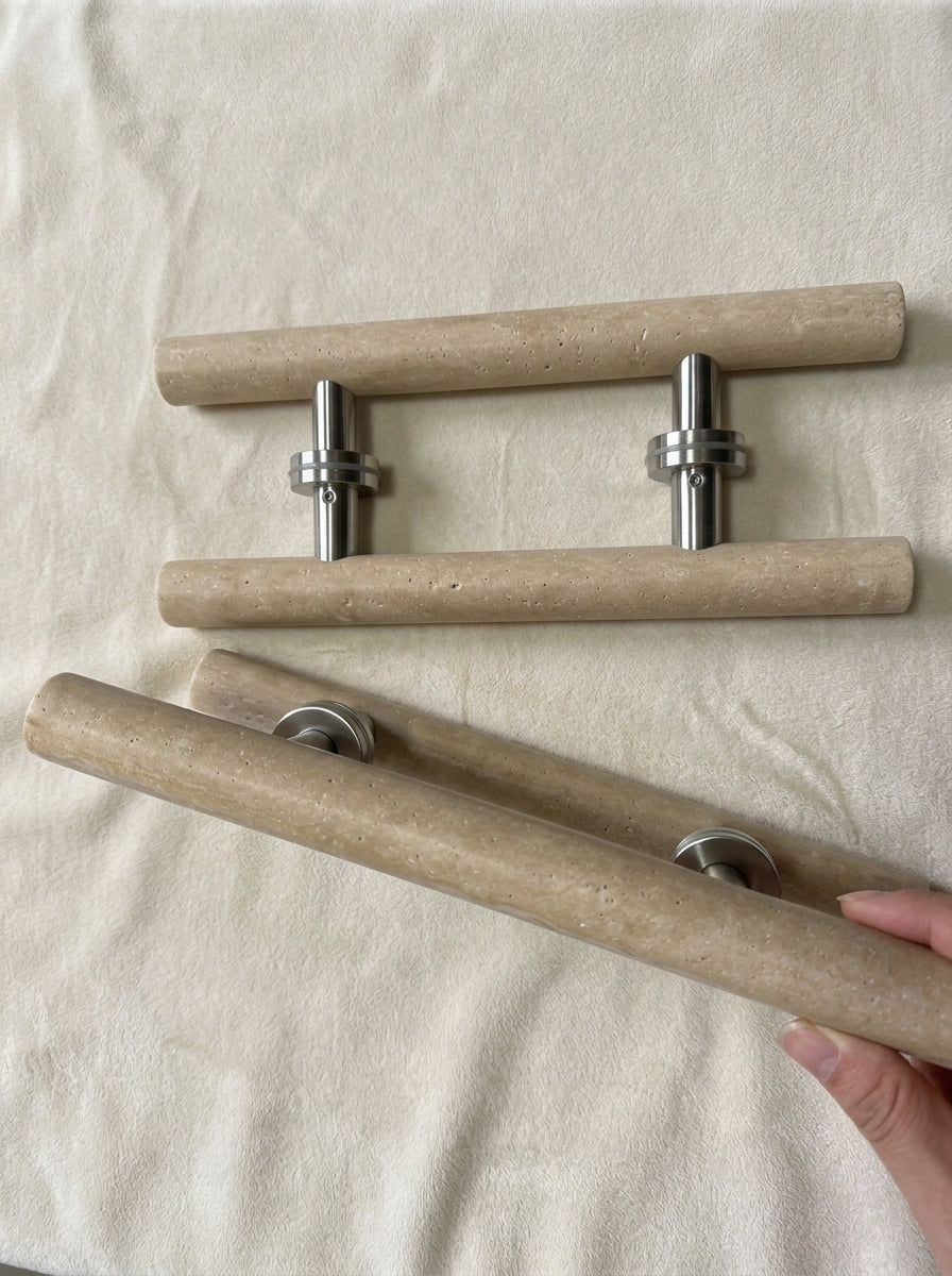Beige travertine cylinder door pull held in hand showing 40 cm length and natural stone texture